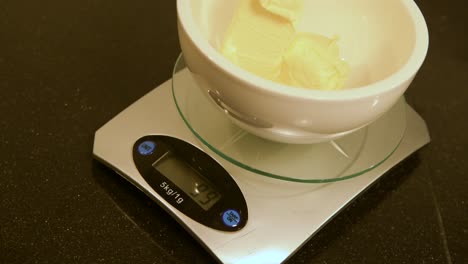 person-weighing-butter-into-a-small-bowl