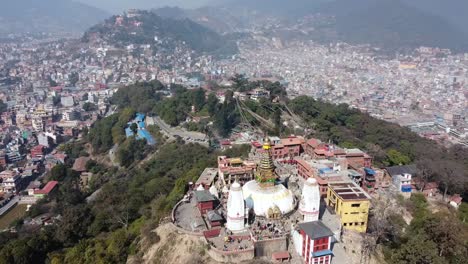 A-view-of-the-Swayambhunath-Stupa-on-the-top-of-a-hill-with-the-city-of-Kathmandu,-Nepal-in-the-background