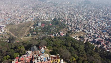 Ein-Blick-Auf-Die-Stadt-Kathmandu,-Die-Hinunterrutscht,-Um-Den-Bhuddistischen-Swayambhunath-Stupa-Auf-Der-Spitze-Eines-Hügels-Zu-Sehen