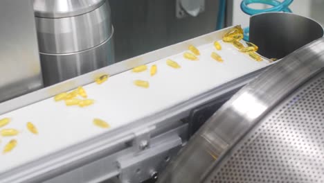 4K-video-of-small-vitamin-pills-moving-onto-a-conveyor-belt-for-drying-before-packaging