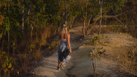 Blonde-woman-with-blue-summer-pants-walks-happily-during-golden-hour-among-the-nature-of-the-Pai-Canyon-in-Mae-Hong-Son-in-thailand