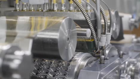 4K-video-of-machinery-pressing-and-molding-omega-vitamins-into-pills-for-the-assembly-line
