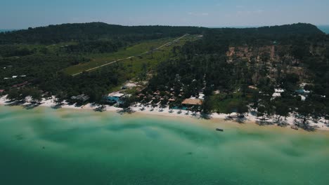 Beautiful-green-blue-sea-on-the-vast-white-sandy-beach-and-large-resorts-between-the-green-nature-of-the-tourist-island-of-Koh-Rong-Sanloem
