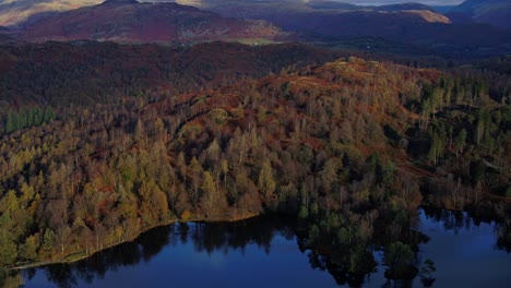 Lake-district-national-park,-UNESCO,-Tarn-Hows-aerial-drone-footage-over-lake-towards-mountains-reveal---dji-inspire-2