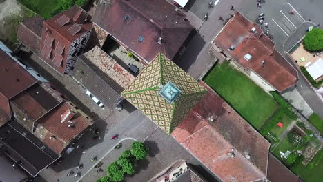 A-pivoting-top-view-aerial-footage-on-top-of-the-clock-tower-while-showing-the-houses-and-moving-cyclists-within-the-village