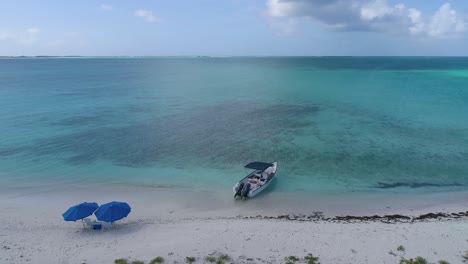 Romantischer-Sonnenuntergang-Karibikinsel-Mit-Boot-Und-Zwei-Strandkörben