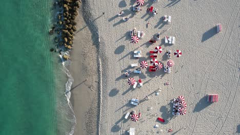 Aerial-view-rising-above-sun-beds-and-parasols-at-Miami-beach,-in-Florida,-USA---birds-eye,-drone-shot