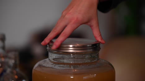 A-stationary-shot-of-a-woman's-hand-while-tightening-the-lid-of-a-jar
