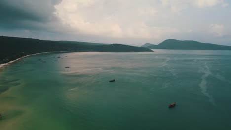 Mehrere-Boote-Sind-An-Einem-Bewölkten-Tag-In-Der-Riesigen-Klaren-Bucht-Der-Kambodschanischen-Insel-Koh-Rong-Sanloem-Festgemacht,-Da-Das-Sonnenlicht-Wunderschön-Reflektiert-Wird