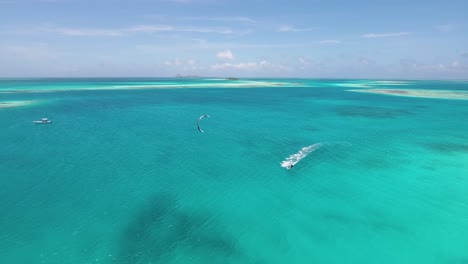 Kitesurfer-Fliegen-Auf-Blauem-Wasser-Karibisches-Meer,-Luftmeerblick-Los-Roques-Venezuela