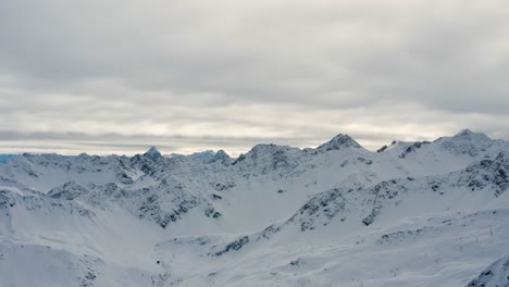 Aerial-Trucking-Shot-Der-Majestätischen-Alpengipfel-Im-Berühmten-Schweizer-Skigebiet-Arosa,-Das-Bei-Bewölktem-Wetter-Mit-Schnee-Bedeckt-Ist