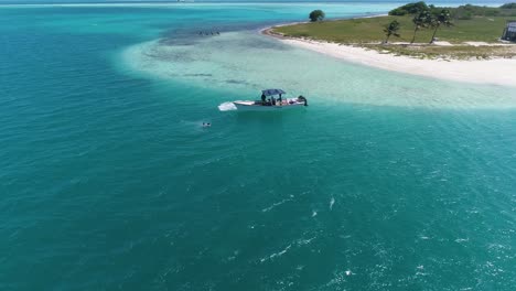 Drone-shot-BOAT-WITH-PEOPLE-BATH-AROUND-Caribbean-island-DOS-MOSQUISES-in-Los-Roques