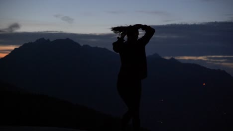 Slow-motion:-Beautiful-shot-of-silhouette-of-a-young-woman-dancing-and-spinning-on-a-plattform-at-dusk