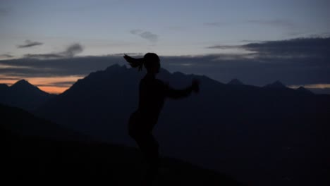 Slow-motion:-Beautiful-shot-of-silhouette-of-a-young-woman-dancing-and-spinning-on-a-plattform-at-dusk