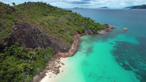 Aufsteigende-Luftaufnahme-Des-Abgelegenen-Strandes-Und-Der-Insel-Mit-Felsiger-Küste-Und-Sand-Auf-Den-Seychellen
