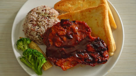 barbecue-pork-steak-with-rice-berry-on-white-plate