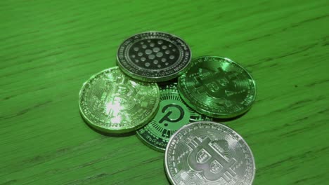 Bitcoin--Und-Polkadot-münzen-In-Grüner-Farbe,-Die-Den-Bullenmarkt-Zum-Mond-Auf-Blockchain-Web-3-Darstellen,-Digitale-Zahlungen,-Lichtreflexionen,-Makroaufnahme-Im-Vordergrund,-Die-Von-Oben-Rollen,-Galizien,-Spanien