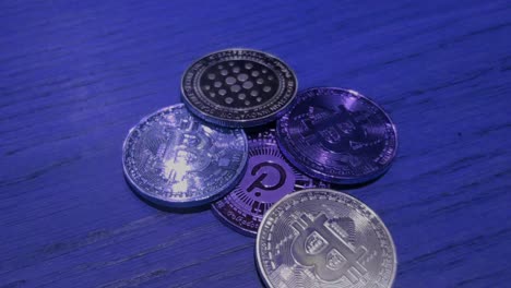 Bitcoin--Und-Polkadot-münzen-In-Blauer-Farbe,-Die-Einen-Sicheren-Markt-Auf-Blockchain-Web-3-Darstellen,-Digitale-Zahlungen,-Lichtreflexionen,-Makroaufnahme-Im-Vordergrund,-Die-Von-Oben-Nach-Hinten-Rollen,-Galizien,-Spanien