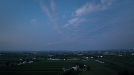An-aerial-view-of-the-lush-green-farmlands-in-the-rural-countryside-of-Lancaster-County,-Pennsylvania-in-the-last-light-of-the-day