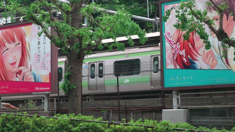 U-Bahn-Zug,-Der-Am-Manga-Schild-In-Tokio-Vorbeifährt,-4k