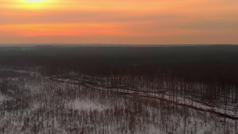 Drone-Shot-Of-Wide-Snowy-Swamp-At-Sunset-Time,-Colorful-Sky,-USA
