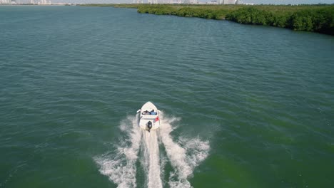 Tracking-Shot-Of-White-Boat-Speeding-In-CANCUN,-Riviera-Maya-Beautiful-Bay,-Mexico