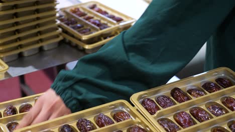 Quality-assurance-employee-weigh-fresh-Medjool-dates-in-packages-before-wrapping
