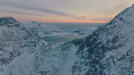 Aerial-view-across-Ramberg-glacial-rocky-mountain-sunrise-peaks-landscape,-Norway