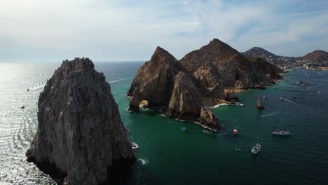 Aerial-view-away-from-rocky-peaks-at-the-cape-of-Cabo-San-Lucas,-Mexico---pull-back,-drone-shot