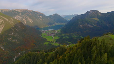 Aerial-view-orbiting-Karwendel-Tyrol-rolling-forested-mountain-valley-lake-wilderness