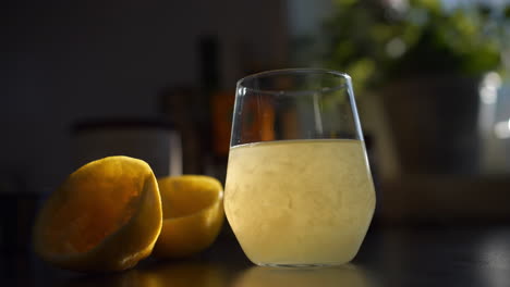 Tracking-shot-of-Freshly-squeezed-lemon-Juice-served-in-glass,-Slow-motion