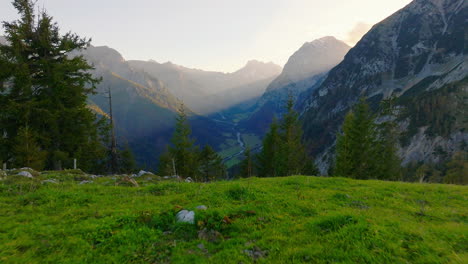 Flying-through-Kerwendel-alpine-treetops-as-sunrays-shine-across-Austrian-mountain-landscape
