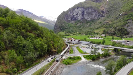 Aerial:-train-by-a-river-entering-to-Flåm-in-Norway