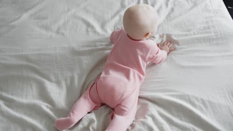 Seven-months-old-baby-learning-to-crawl-on-bed-get-up-on-all-fours