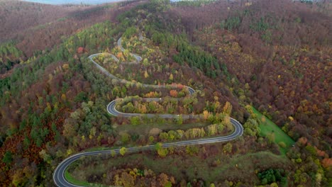 Video-Aéreo-De-Un-Sinuoso-Camino-De-Montaña-Rodeado-Por-Un-Bosque-Con-árboles-De-Otoño-En-Las-Montañas-Bieszczady-En-Polonia,-Europa