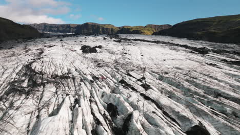 Low-flyover-over-hikers-exploring-surface-of-massive-Icelandic-glacier