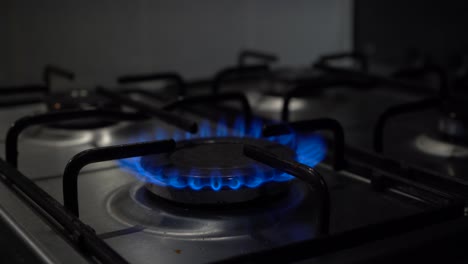 Hot-blue-flame-on-gas-stove-ignites-and-sputters-with-orange-bursts