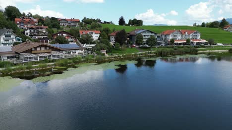 Lago-Hopfensee-Y-Ciudad-Hopenfen-Swabia-Baviera-Alemania-Panning-Drone-Vista-Aérea-4k