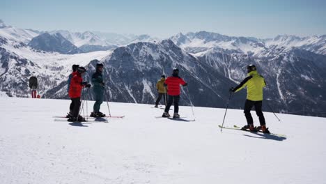 Skiers-skiing-down-with-the-mountain-panorama-in-the-background