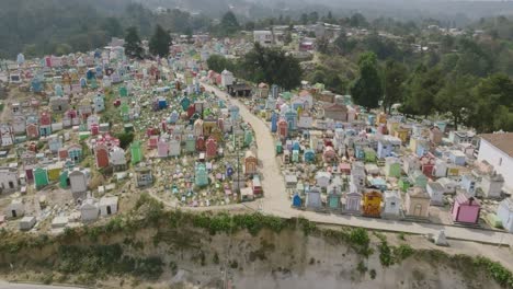 Aerial-footage-that-flies-over-a-path-that-cuts-through-the-middle-of-a-colorful-cemetery-in-Chichicastenango,-Guatemala