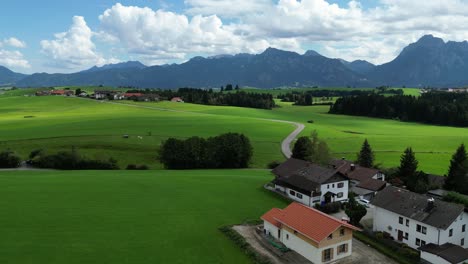 Green-Alpine-fields-Hopfensee-Hopenfen-town-in-Swabia-Bavaria-Germany-drone-aerial-view