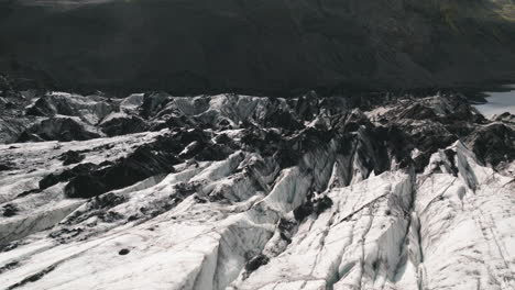 Low-aerial-tracking-shot-over-cracks,-crevasses-in-surface-of-Iceland-glacier