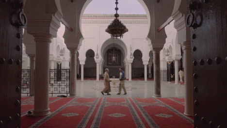 Mann-In-Traditionellen-Arabischen-Muslimischen-Gewändern-Trifft-Mann-In-Moderner-Kleidung-Mitten-In-Der-Moschee,-Schöne-Komposition,-Vorwärtsbewegung