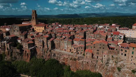 Pitigliano,-a-famous-Tuscany-town-on-Etruscan-tufa-rocks-with-old-houses-and-buildings-near-beautiful-Siena-and-Florence,-Italy,-close-to-wine-and-vinery-area,-seen-from-above-by-drone-as-aerial-view