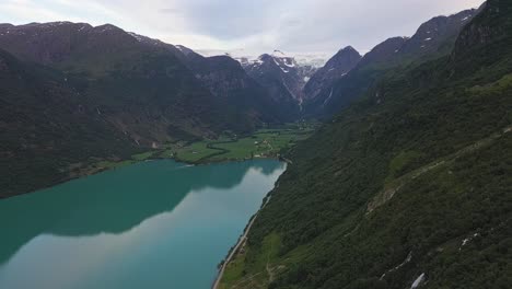 Briksdal-glacier-in-montains-behind-Olden-and-oldevatn-glacial-green-freshwater-lake-in-Nordfjord-Norway---Famous-destination-with-glacier-part-of-the-Jostedal-glacier---Aerial-view-from-mountainside