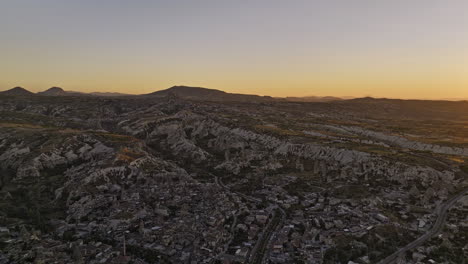 Göreme-Turkey-Aerial-v2-panoramic-panning-sunset-view-along-the-skyline,-surreal-cappadocia-landscape-of-rock-formations-with-glowing-sun-setting-on-the-horizon---Shot-with-Mavic-3-Cine---July-2022