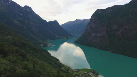 Cuento-De-Hadas-Antiguo-Y-Paisaje-De-Postal-Con-Montañas-Empinadas-Y-Un-Lago-De-Agua-Dulce-Verde-Glacial-Muy-Abajo---Impresionante-Vista-Aérea-Desde-La-Exuberante-Ladera-Verde---Nordfjord-Noruega