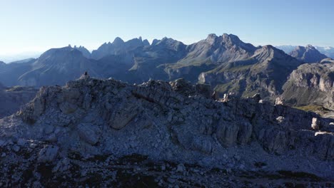 Hiker-sitting-on-the-mountain-peak-in-Dolomites,-mountain-landscape-panorama