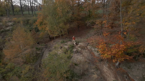 Tourist-photographer-taking-photos-in-forest-or-nature,-drone-fly-back-view