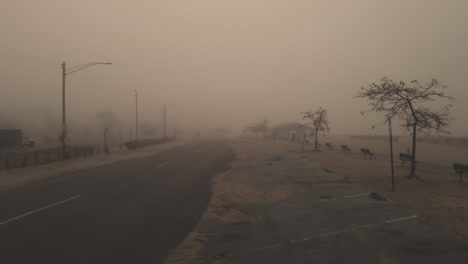 Empujando-Hacia-Adelante-A-Lo-Largo-De-Una-Calle-Arenosa-Durante-La-Niebla-Pesada